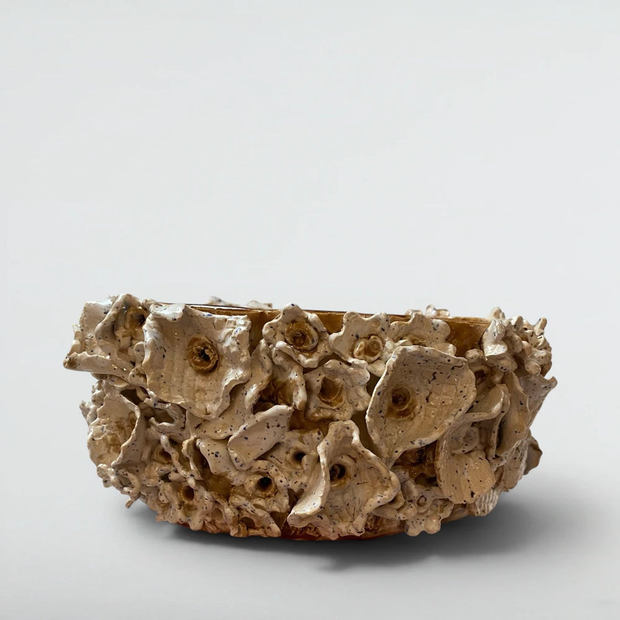 Sculptural ceramic centrepiece with hand-rolled blossoms, speckled white glaze pooling to amber in deep places