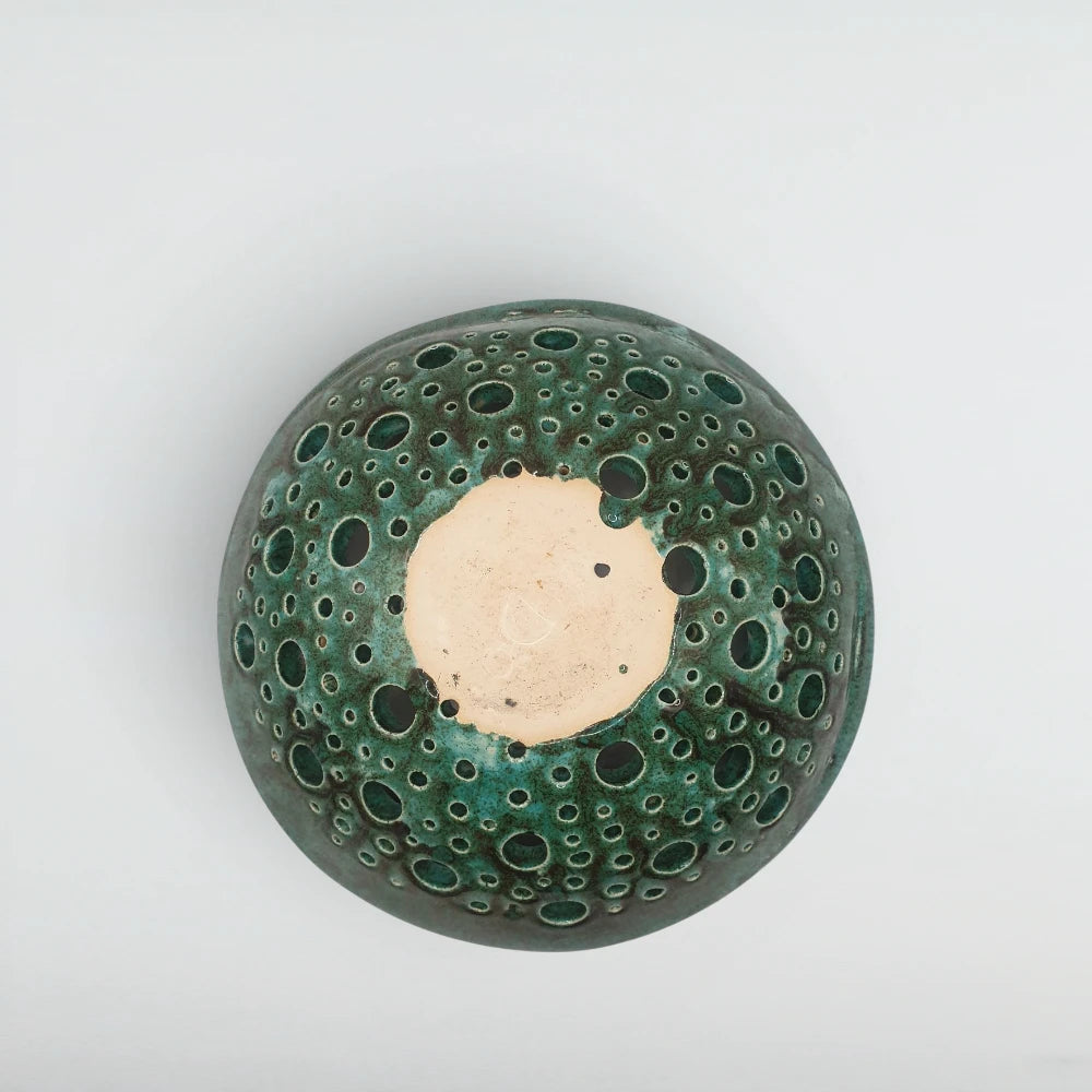Underside of the Atoll ceramic bowl showing pale stoneware clay visible at each pierced opening