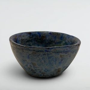Small hand-thrown tea bowl in crystalline blue glaze with frost-fern patterns over dark clay