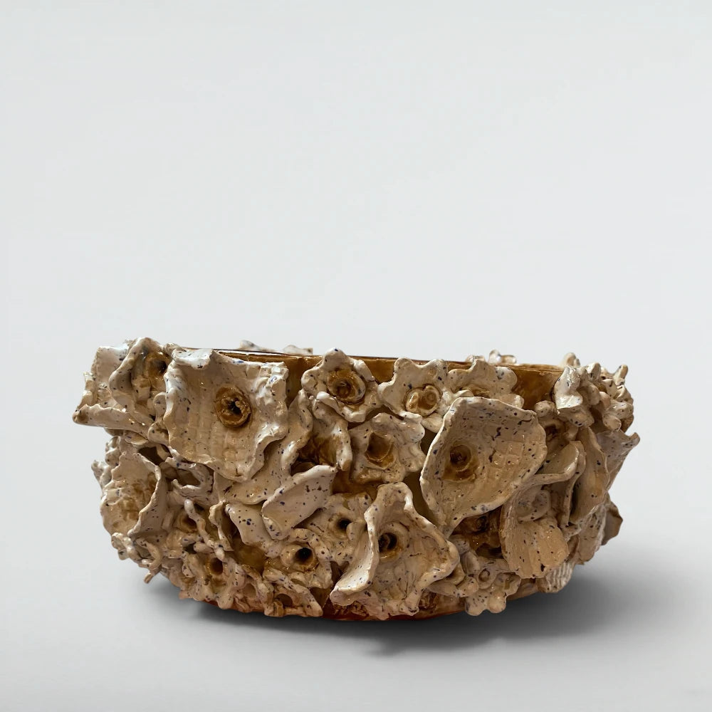 Sculptural ceramic centrepiece with hand-rolled blossoms, speckled white glaze pooling to amber in deep places