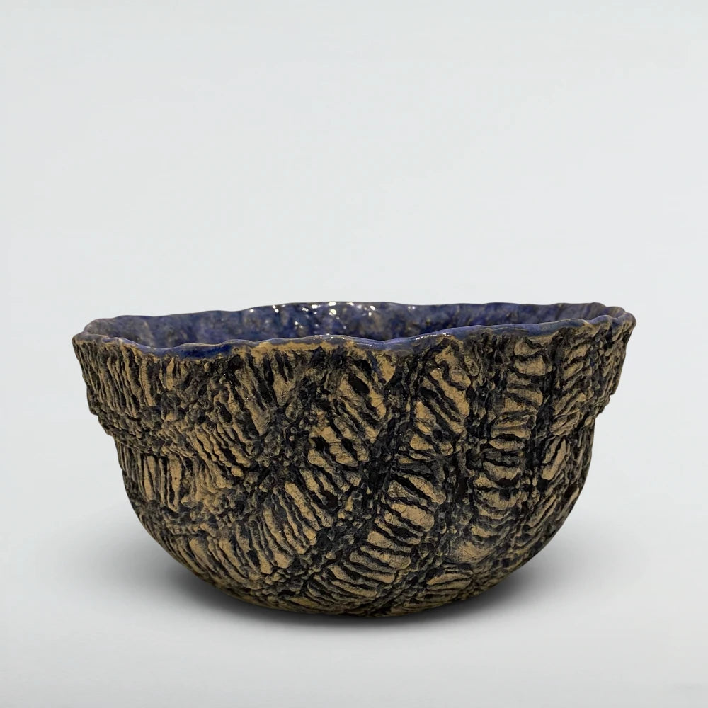 Exterior detail of the Tide bowl showing chip-carved indigo and bone texture with hundreds of hand-cut marks