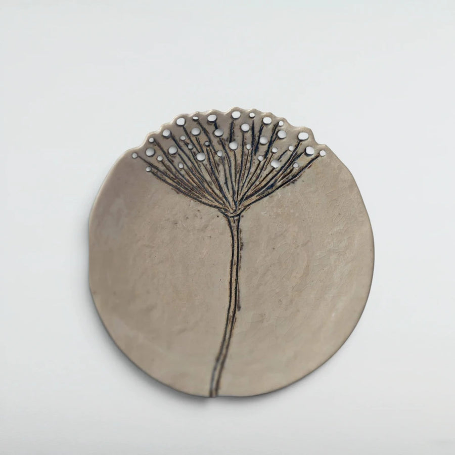 Cream crackle-glazed ceramic wall plate carved with a single wild yarrow stem, its flower head bursting into pierced holes